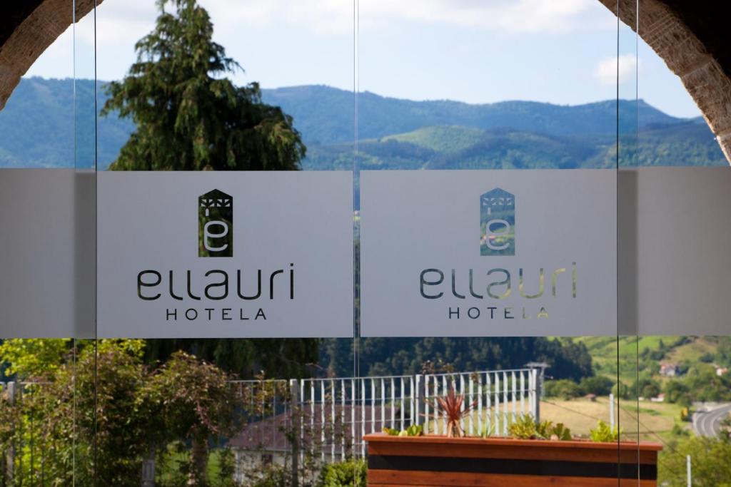 una señal para un hotel con montañas en el fondo en Ellauri Hotel - Adults Only, en Zeanuri
