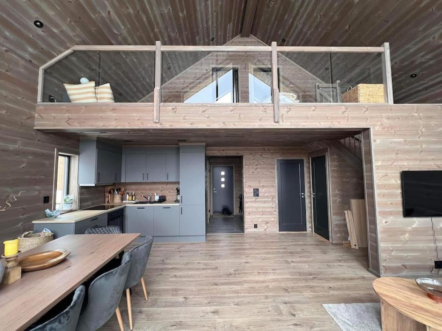 uma cozinha e sala de jantar com uma grande mesa de madeira em Rindabotn Fjelltun em Sogndal