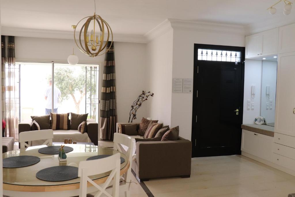 a living room with a table and chairs and a black door at Luxury house directly on the beach in Bizerte