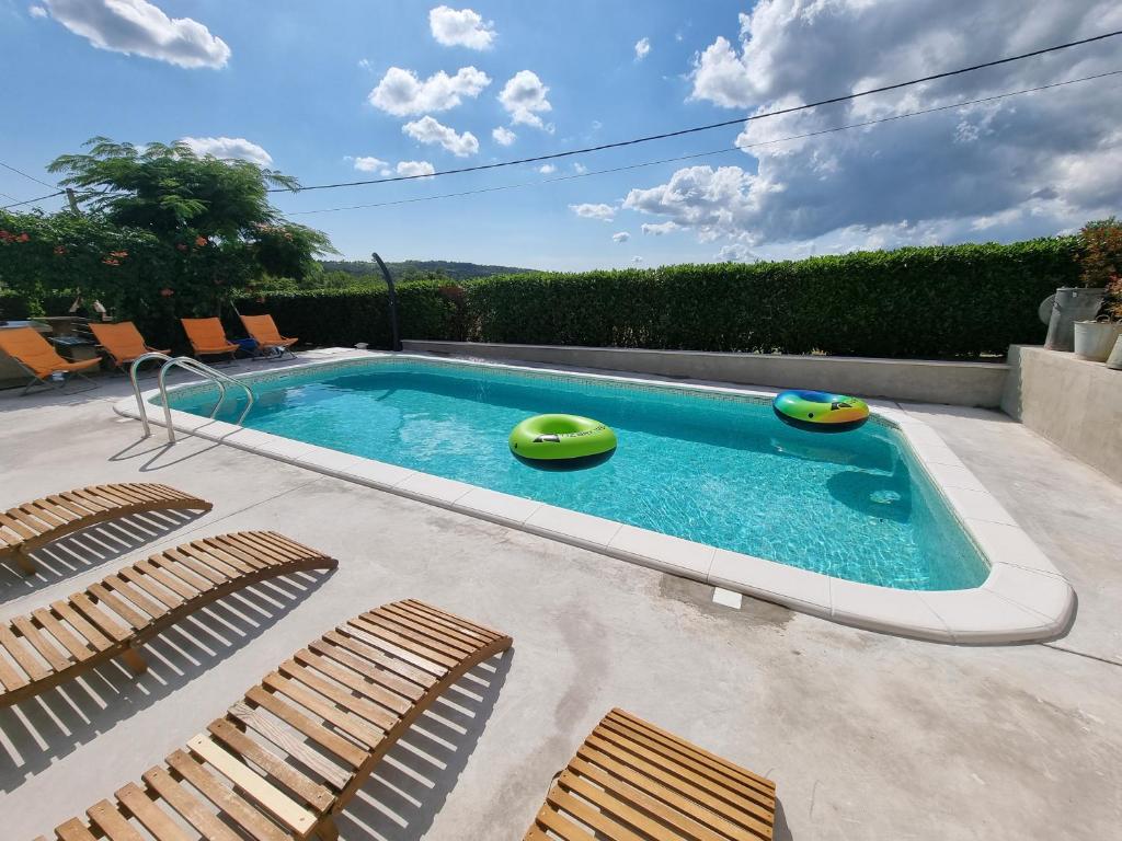 una piscina con 2 sillas y una piscina en Casa Luana, en Roč