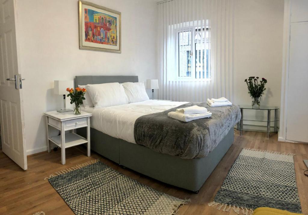 ロンドンにあるCity location- 2 bedroom apartmentのベッドルーム1室(ベッド1台、タオル2枚付)