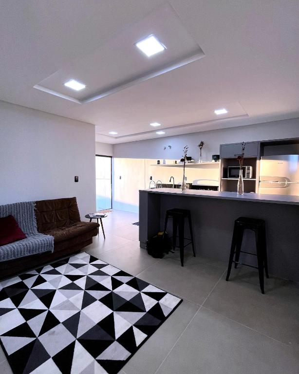 Apartamento La Vie في ساو جواكيم: غرفة معيشة كبيرة مع أريكة ومطبخ