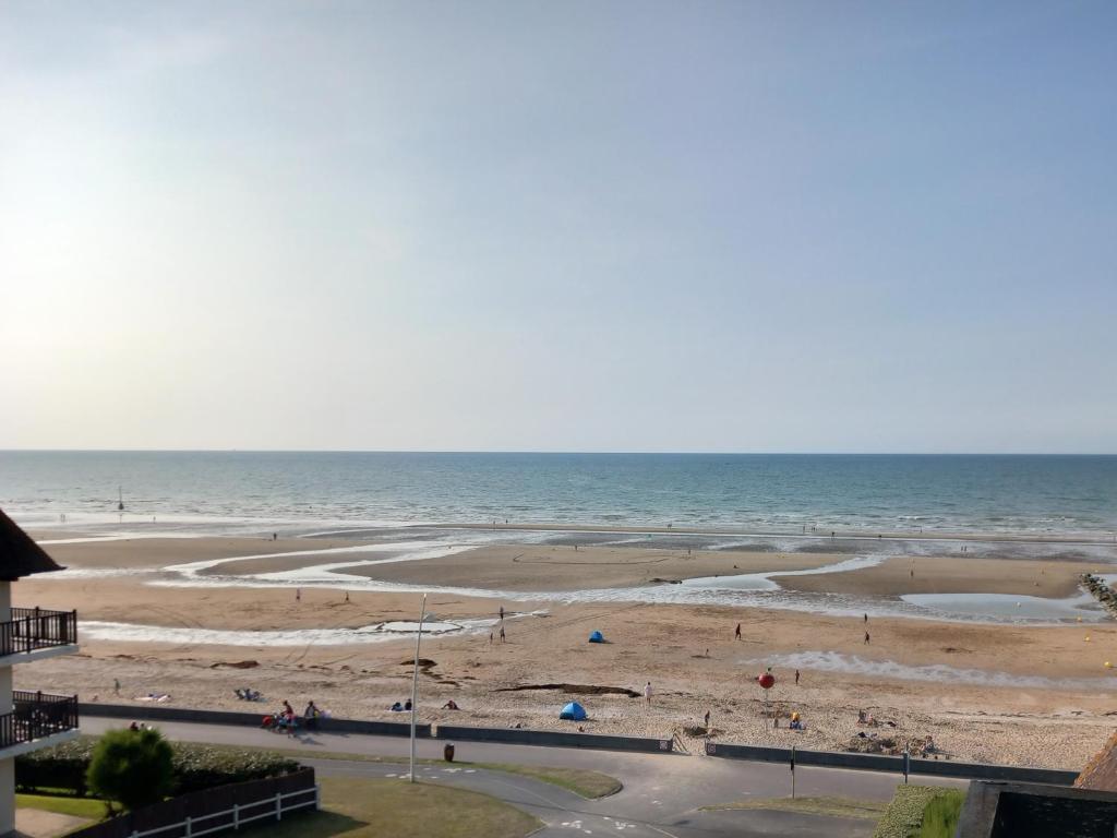 a beach with people on the sand and the ocean at Appartement Liza 2 pièces Vue Mer à Cabourg in Cabourg