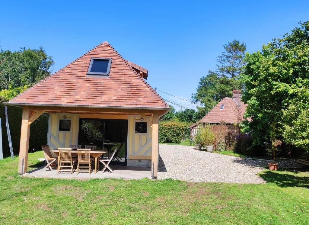 - un pavillon avec une table et des chaises dans un jardin dans l'établissement La Grange, à Auberville