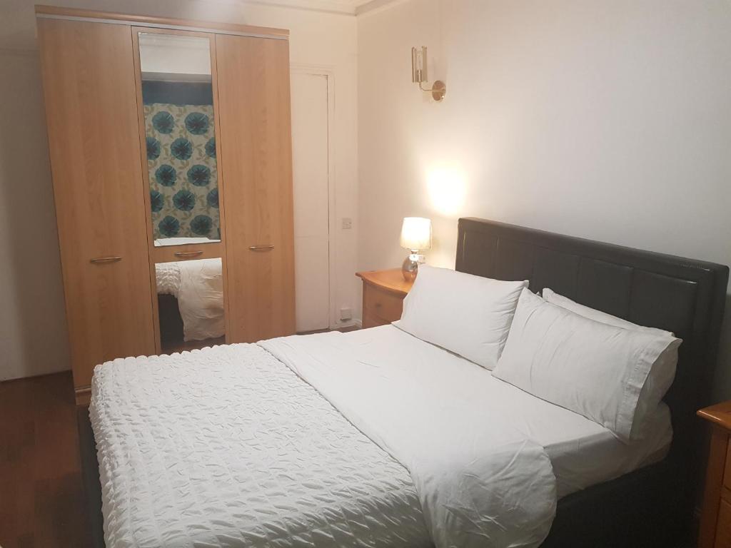 um quarto com uma cama com lençóis brancos e almofadas em Family Lodge, Princess Lodge, Executive Lodge, Master's Lodge em Seven Kings