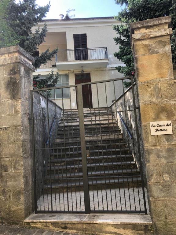 an iron gate leading to a house with a staircase at Casa del Dottore in Fano Adriano