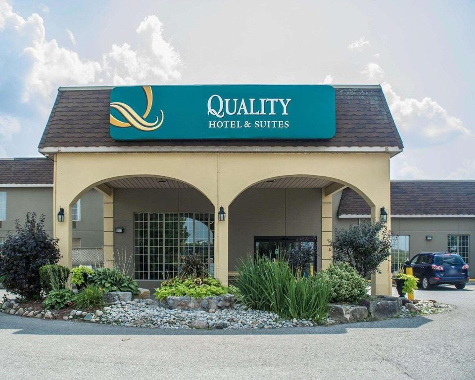 a quality hotel and suites sign on the front of a building at Quality Hotel & Suites Woodstock in Woodstock