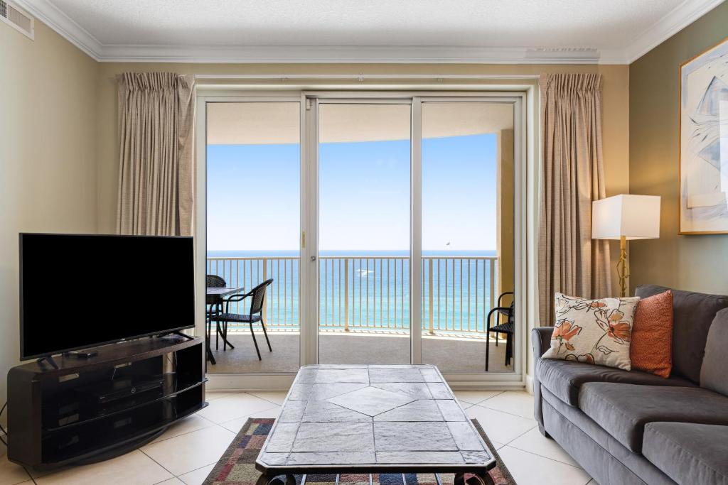 a living room with a couch and a flat screen tv at PARKING INCLUDED-Beachfront 2BD Ocean Villa! Gorgeous Amenities, Private Complex in Panama City Beach
