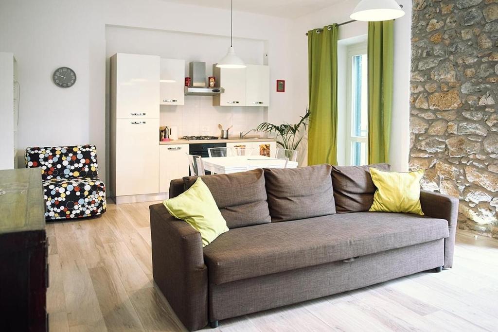 sala de estar con sofá y cocina en Casa Desdy, en Tuscania