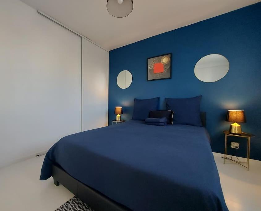 1 dormitorio azul con 1 cama grande y paredes azules en LE CHIC ETHNIC DREUX 52m2 - 50 MIN DE PARIS - PARKING GRATUIT en Dreux