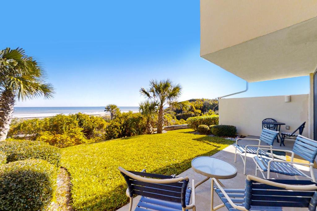 une terrasse avec une table et des chaises et l'océan dans l'établissement Captains Court 1031, à Fernandina Beach