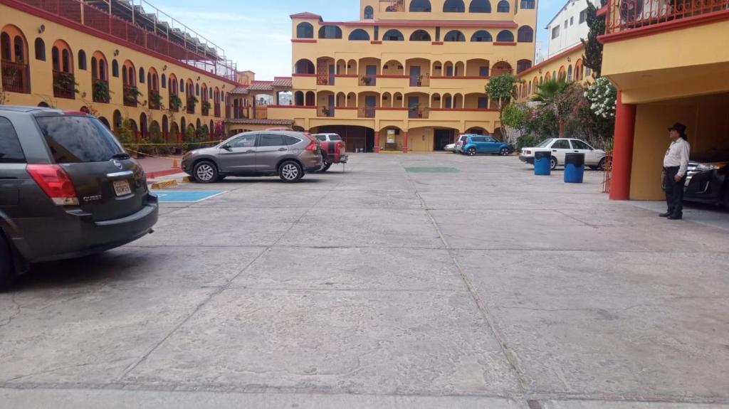 a parking lot with cars parked in front of a building at HOTEL SEVILLA in Tijuana