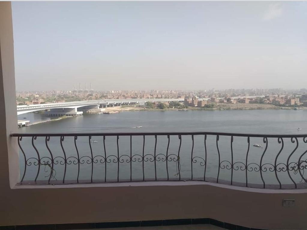 een balkon met uitzicht op een rivier en een brug bij HousRom in Caïro