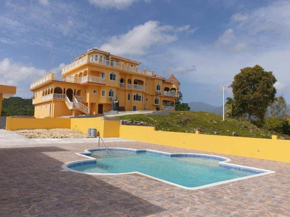 una casa grande con piscina frente a ella en Round View Guest House en Port Antonio