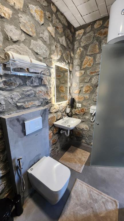 uma casa de banho em pedra com um WC e um lavatório em RUSTICO em Široka