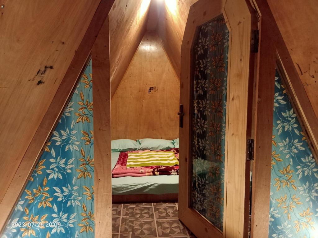 a small room with a bed in a tiny house at Croods farm house in Kodaikānāl