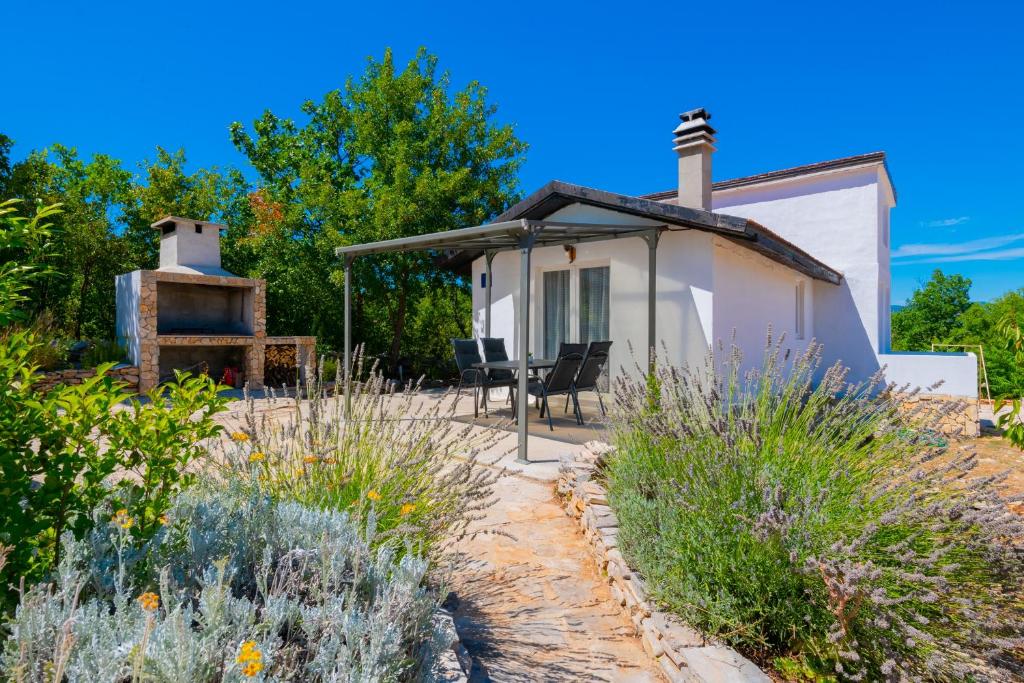 une petite maison blanche avec un grill dans une cour dans l'établissement Family friendly house with a parking space Imotski, Zagora - 21150, à Podbablje