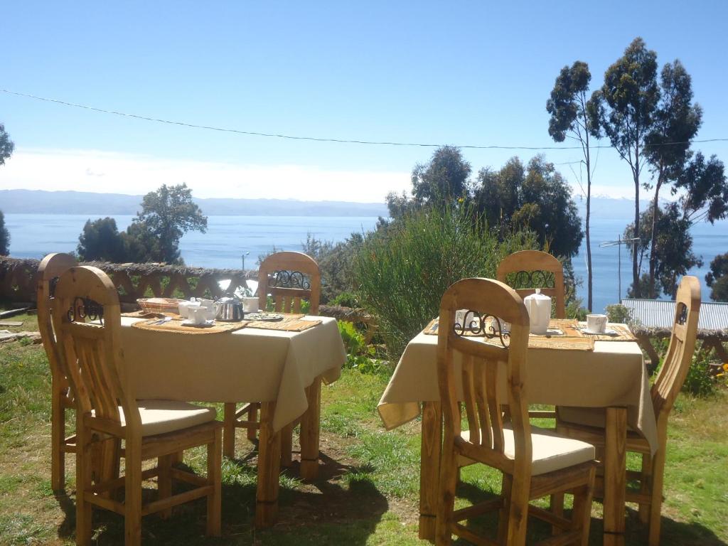 a table and chairs with a table and a view at Hostal del Sol Isla del Sol in Isla de Sol