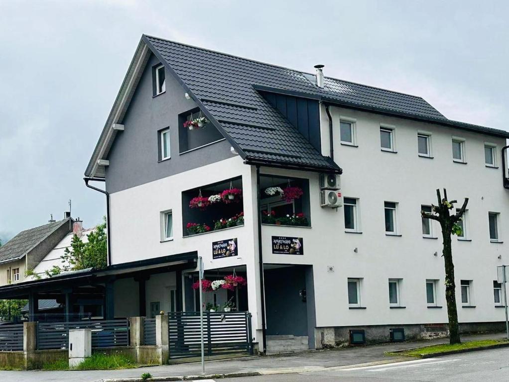 a large white building with flowers in the windows at Apartments with parking space Delnice, Gorski kotar - 21611 in Delnice