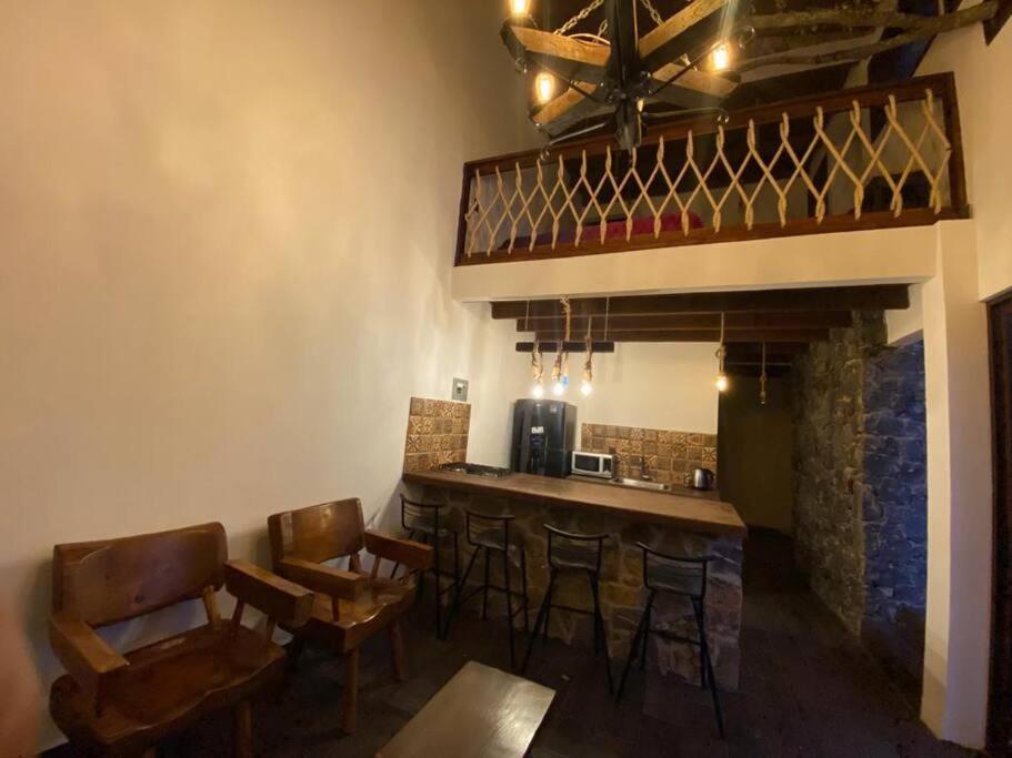 un bar con sillas y una barra en una habitación en Cabañas MiNa's, en Huasca de Ocampo