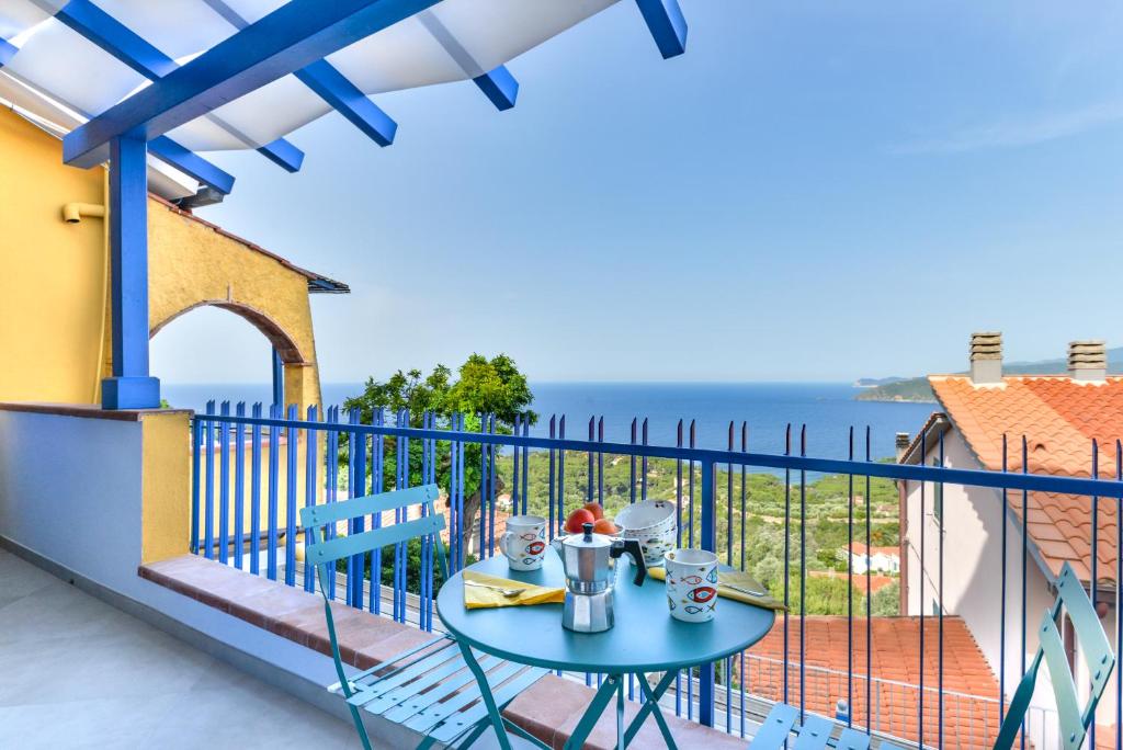 a table on a balcony with a view of the ocean at Galatea - Bel Horizonte in Capoliveri