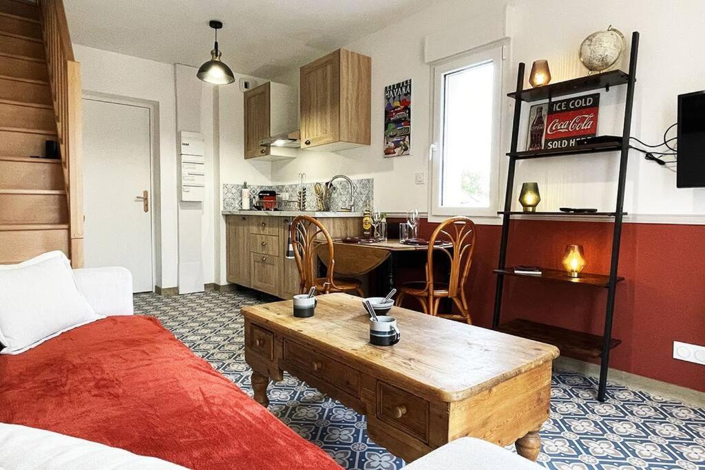 ein Wohnzimmer mit einer Küche und einem Tisch. in der Unterkunft Voyage à Little Havana in Bouguenais