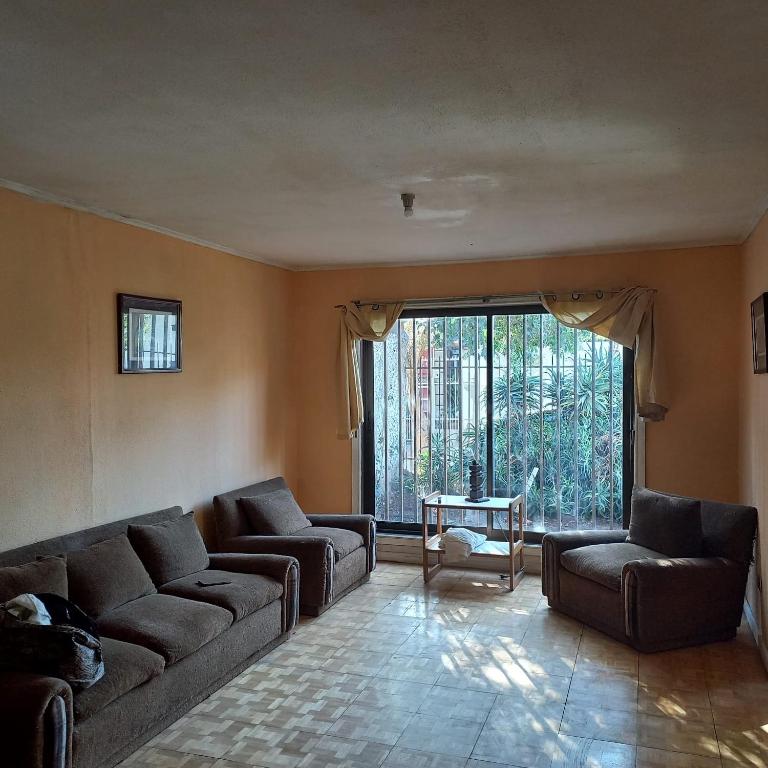 a living room with two couches and a large window at Ulises Galvez in Santiago