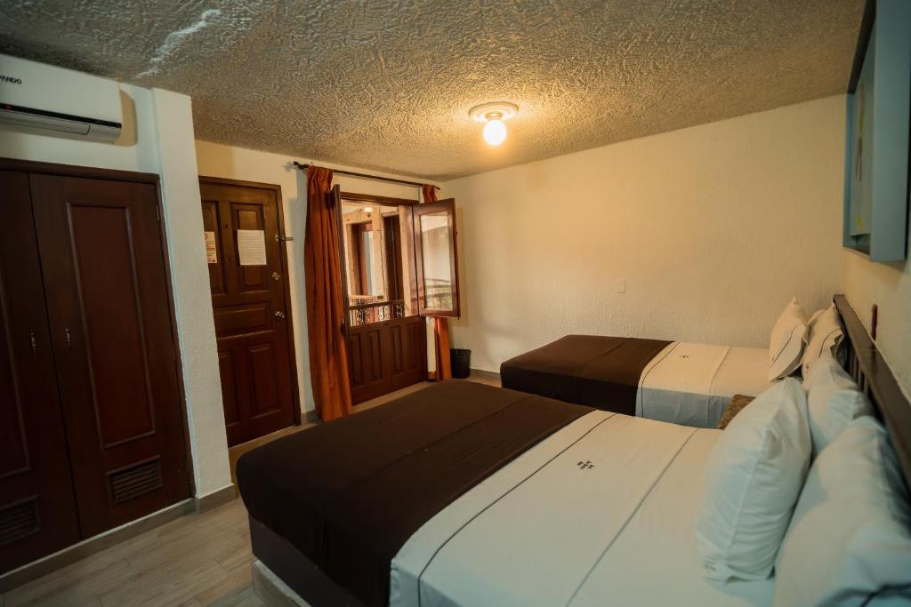 Postel nebo postele na pokoji v ubytování Hotel Don Quijote Plaza - Guadalajara Centro Historico