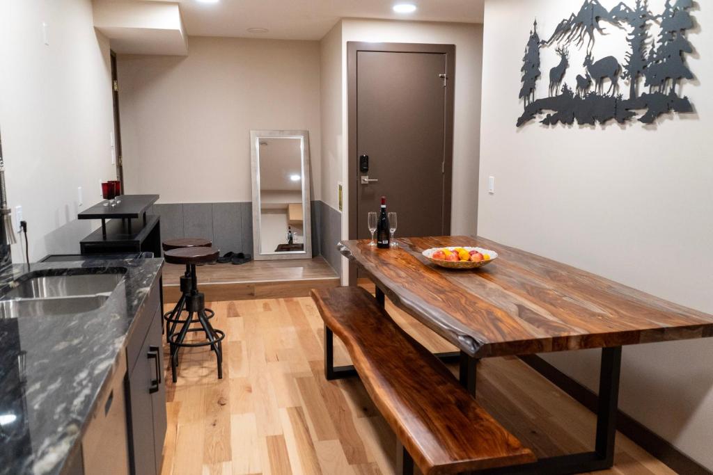 a kitchen with a wooden table with a bowl of fruit on it at Romantic Luxury Retreat with Private Sauna & Spa, Pet Friendly, Elkside Hideout B&B in Canmore