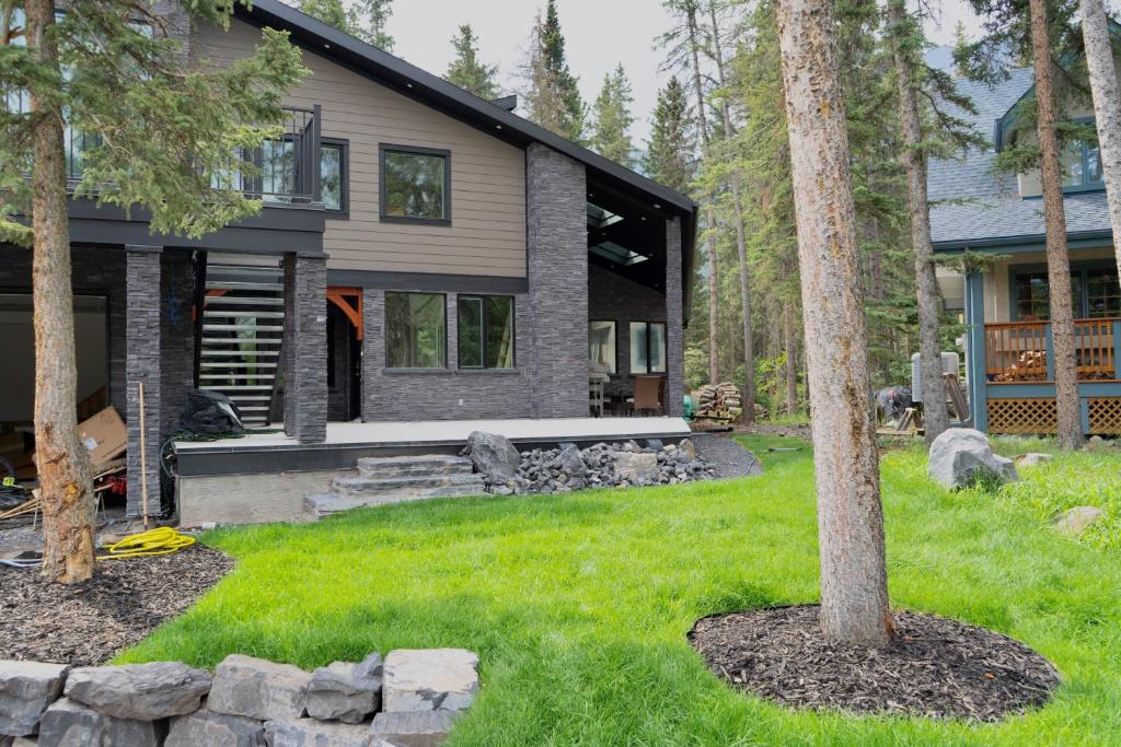 a house with a tree in the yard at Romantic Luxury Retreat with Private Sauna & Spa, Pet Friendly, Elkside Hideout B&B in Canmore