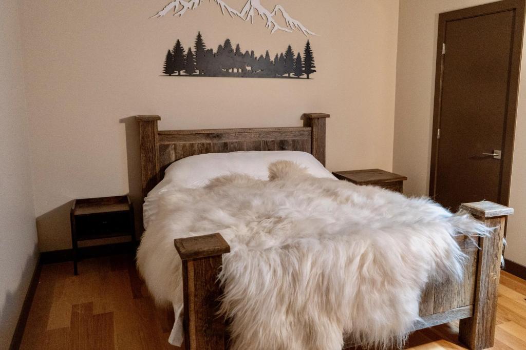 a bedroom with a bed with a white blanket at Romantic Luxury Retreat with Private Sauna & Spa, Pet Friendly, Elkside Hideout B&B in Canmore