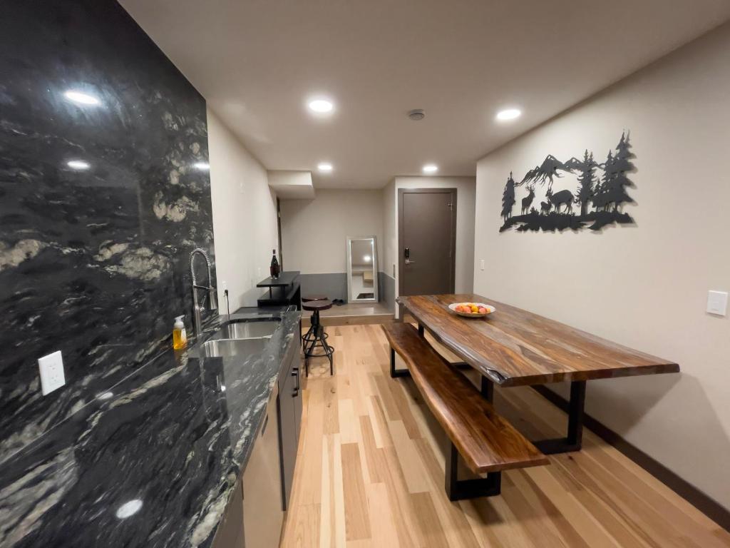 a room with a wooden table and a counter at Romantic Luxury Retreat with Private Sauna & Spa, Pet Friendly, Elkside Hideout B&B in Canmore