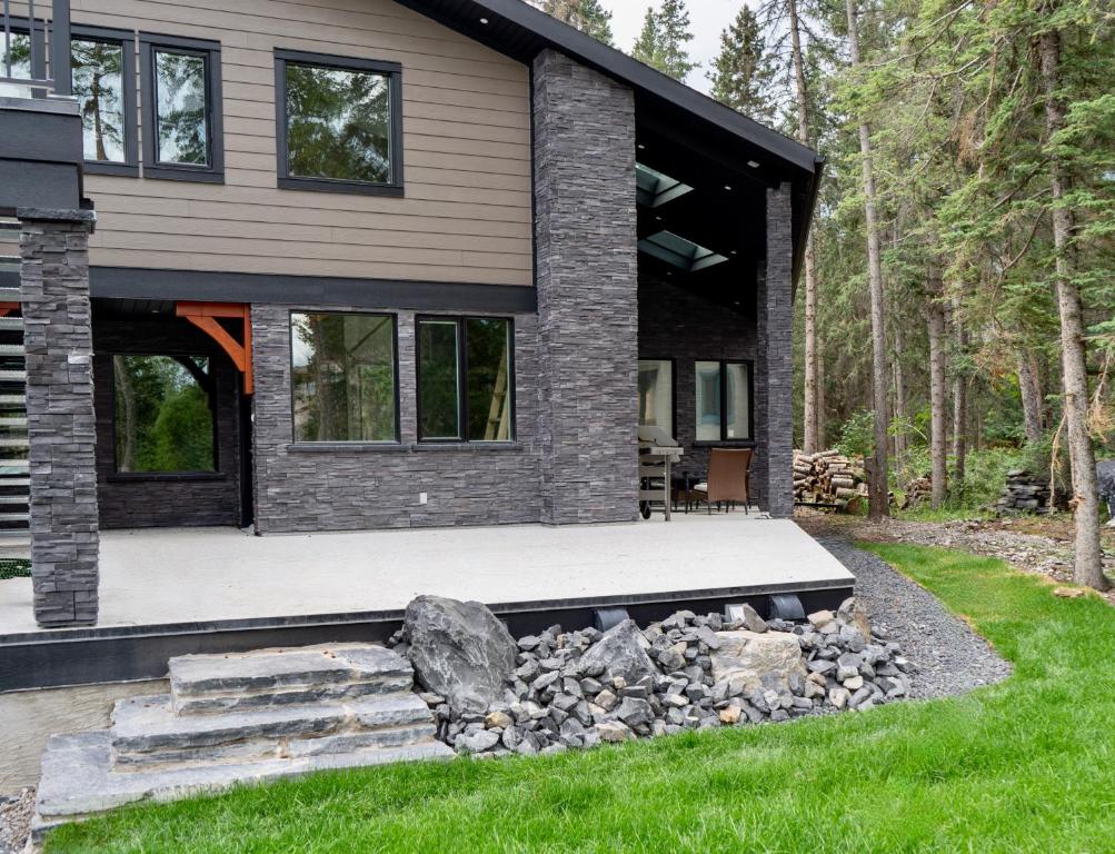 a house with a rock garden in front of it at Romantic Luxury Retreat with Private Sauna & Spa, Pet Friendly, Elkside Hideout B&B in Canmore