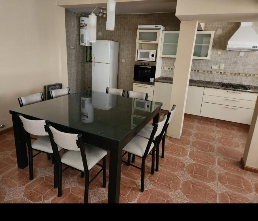 a dining room table with chairs and a kitchen at Casa nueva centrica in San Rafael