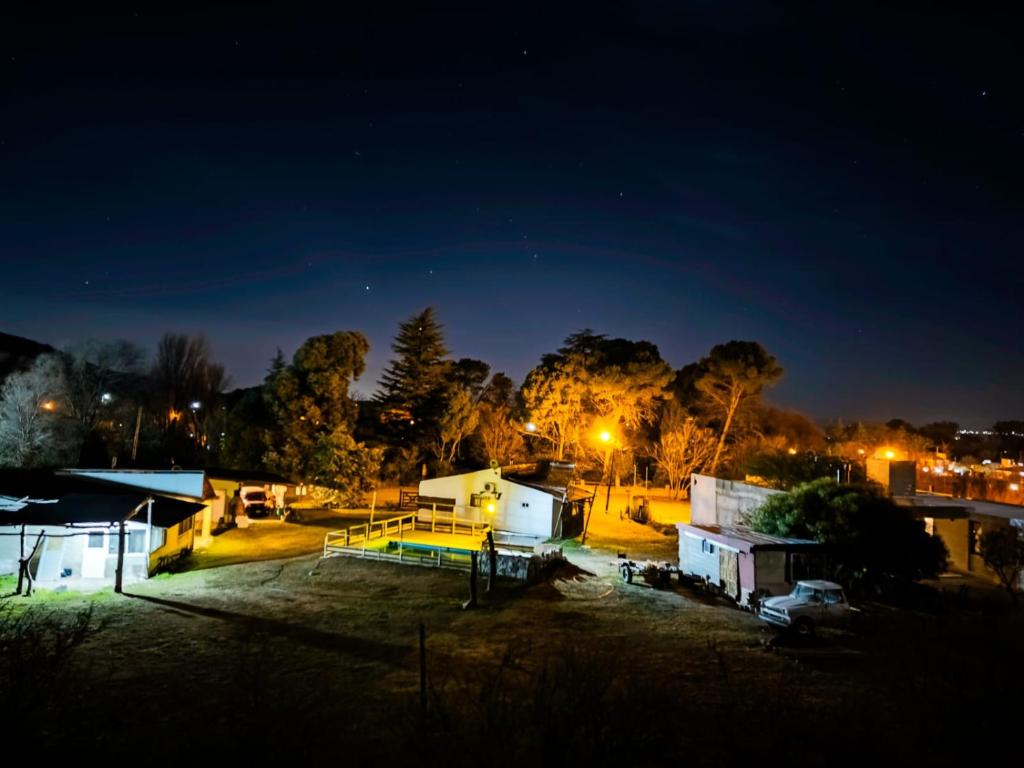 eine Gruppe von Gebäuden in der Nacht mit Lichtern in der Unterkunft Cabañas Buen Ayre in Villa Rumipal
