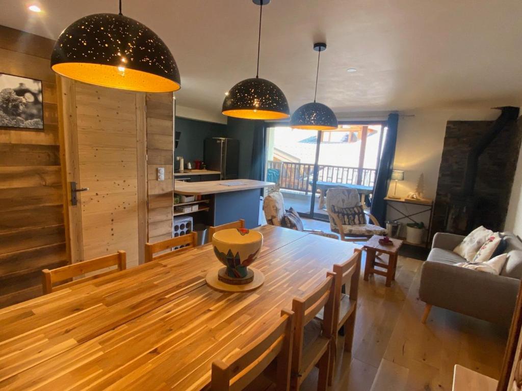 uma cozinha e sala de estar com uma mesa de madeira e luzes pendentes em Appartement Montgenèvre, 4 pièces, 8 personnes - FR-1-445-192 em Montgenèvre