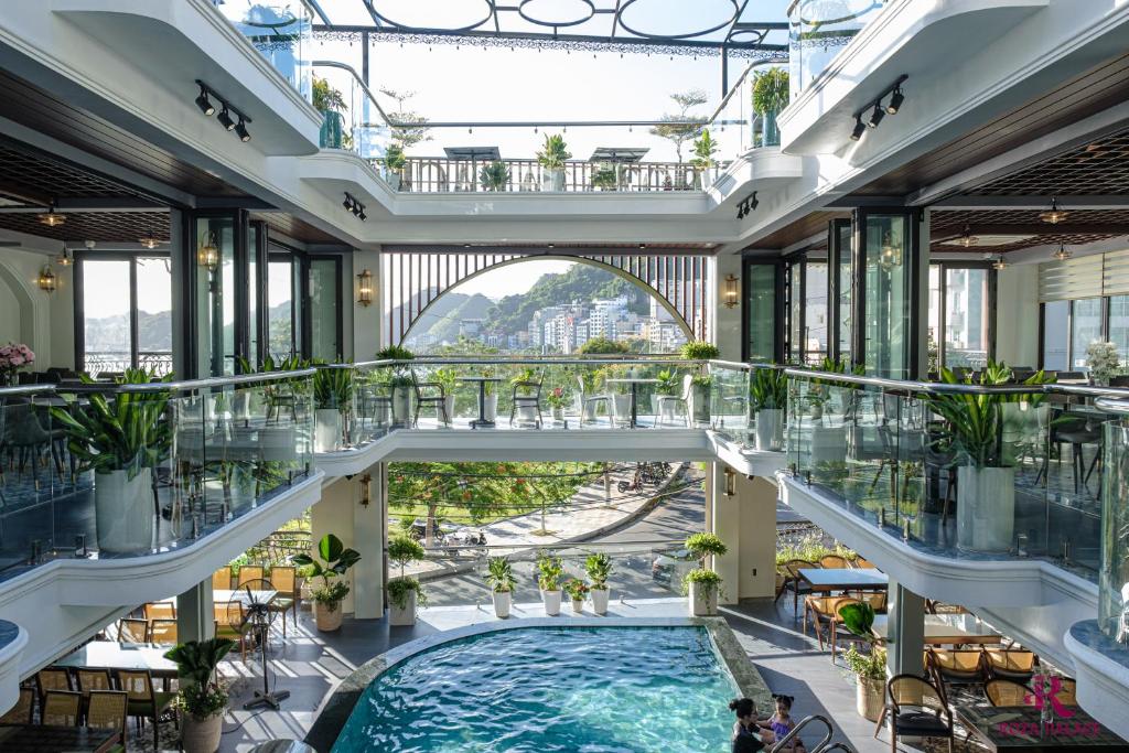 a large indoor pool in a building with glass ceilings at Roza Palace in Cat Ba