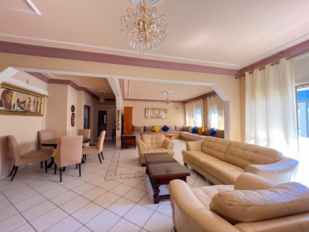 uma sala de estar com sofás e uma sala de jantar em Appartement en plein centre ville em Kenitra