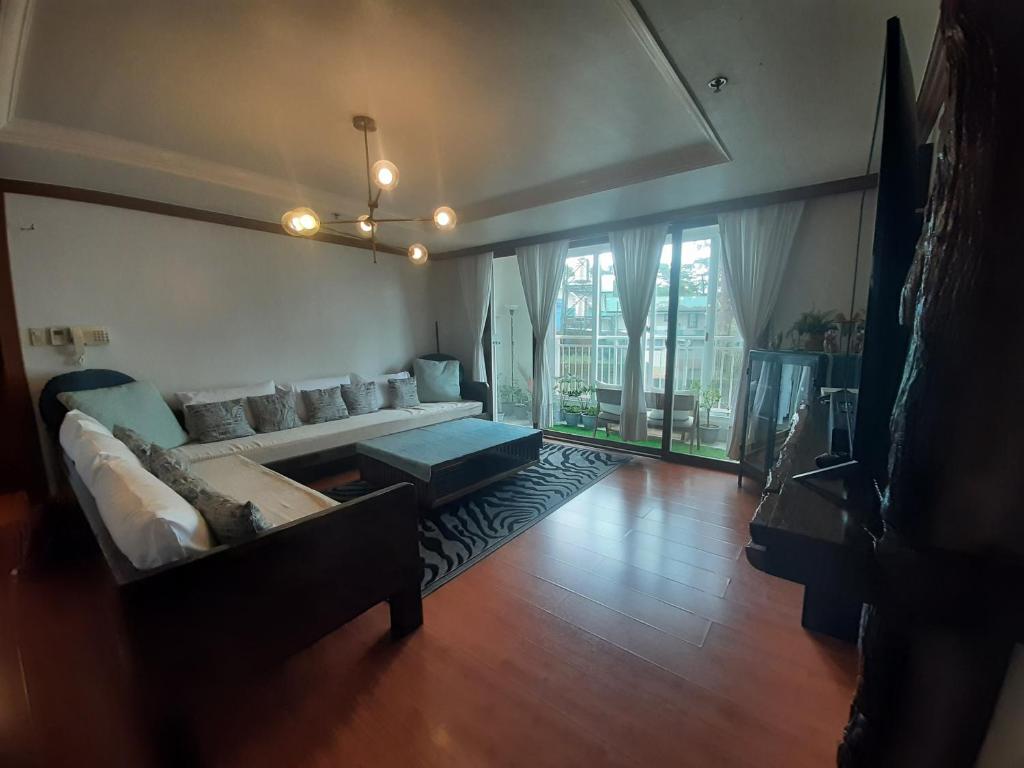 een woonkamer met een bank en een groot raam bij Minesview condo in Baguio