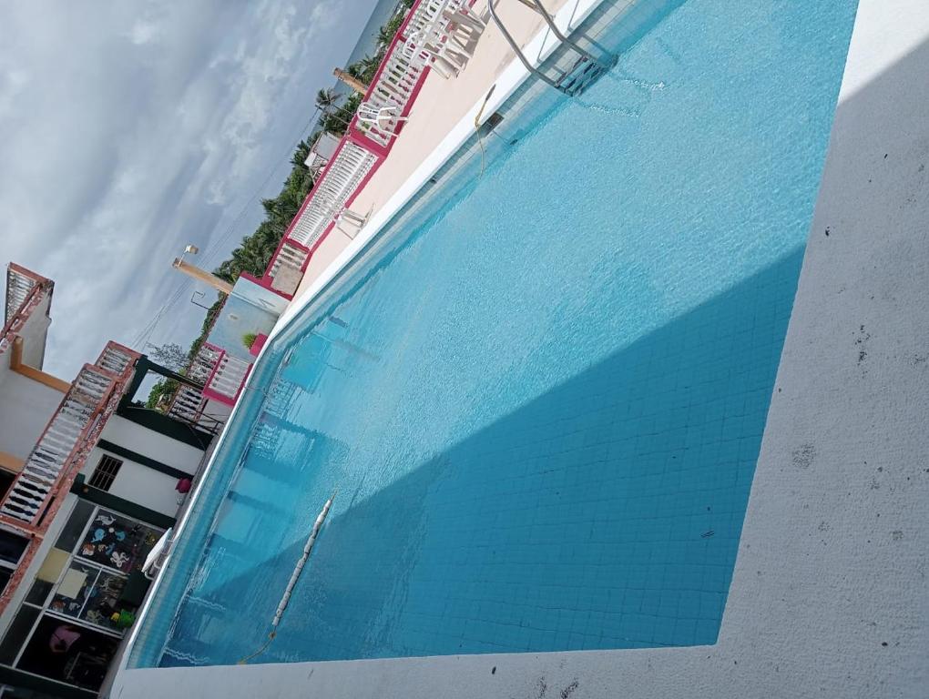 une grande piscine à côté d'un bâtiment dans l'établissement Hotel Casa Cactus HCC, à Chachalacas