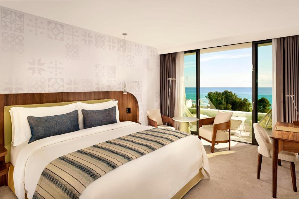 a bedroom with a large bed with a view of the ocean at Parklane, a Luxury Collection Resort & Spa, Limassol in Limassol