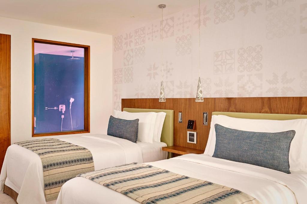 a hotel room with two beds and a window at Parklane, a Luxury Collection Resort & Spa, Limassol in Limassol
