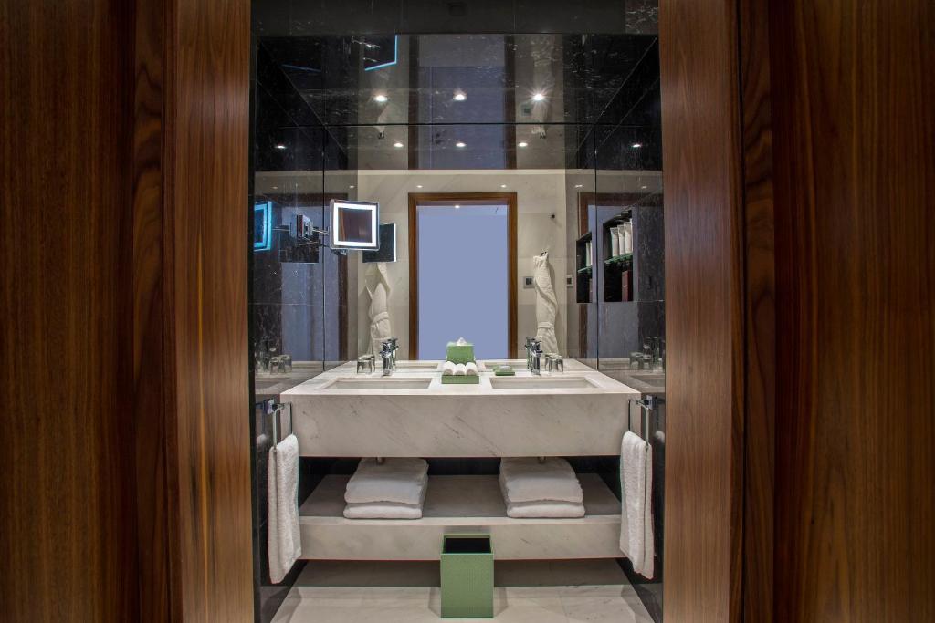 a bathroom with a large tub and a sink at Parklane, a Luxury Collection Resort & Spa, Limassol in Limassol