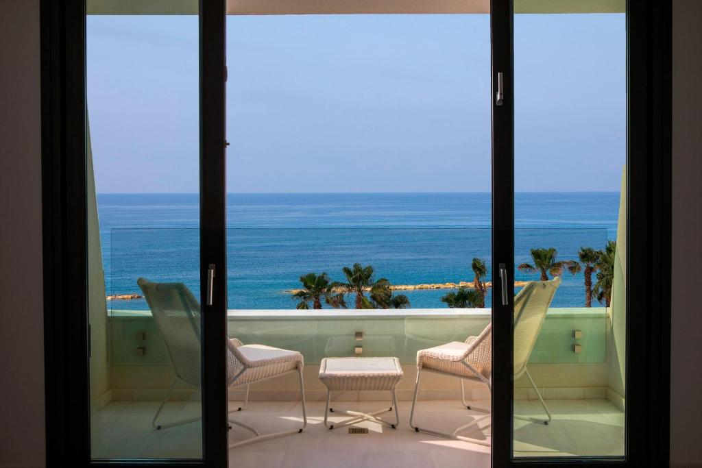 a room with a view of the ocean from a balcony at Parklane, a Luxury Collection Resort & Spa, Limassol in Limassol