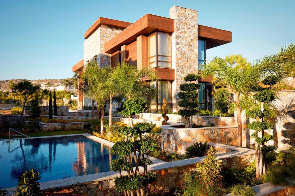 a house with a swimming pool in front of it at Parklane, a Luxury Collection Resort & Spa, Limassol in Limassol
