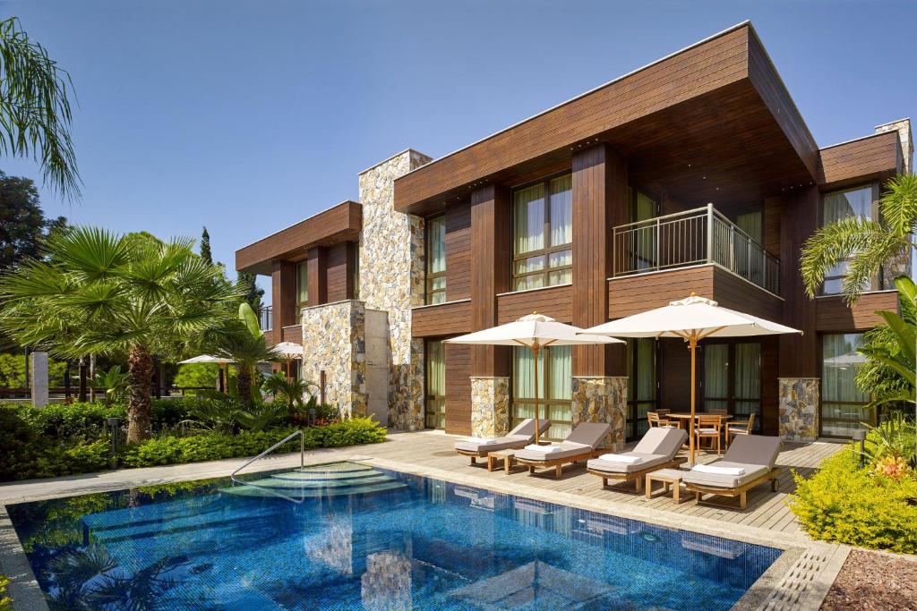 an exterior view of a house with a swimming pool at Parklane, a Luxury Collection Resort & Spa, Limassol in Limassol