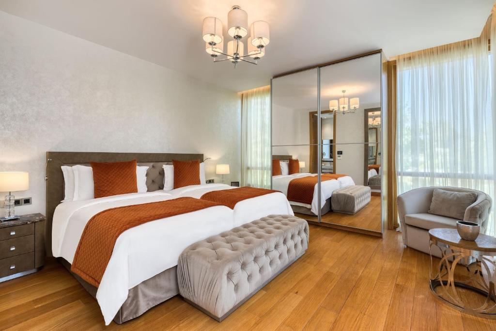 a large bedroom with a large bed and a chair at Parklane, a Luxury Collection Resort & Spa, Limassol in Limassol