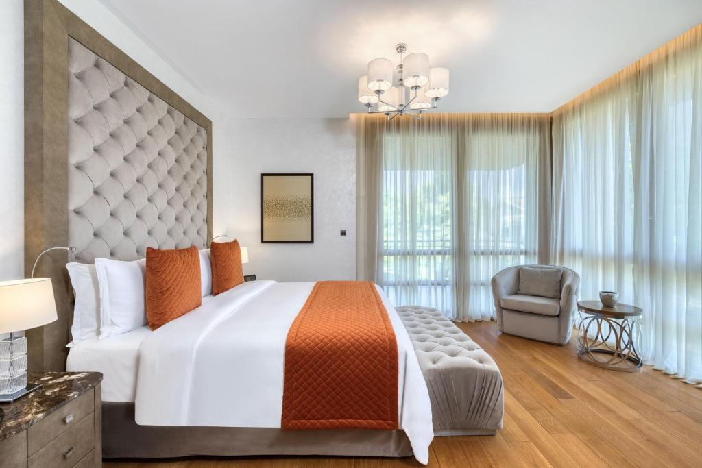 a bedroom with a large bed and a chair at Parklane, a Luxury Collection Resort & Spa, Limassol in Limassol