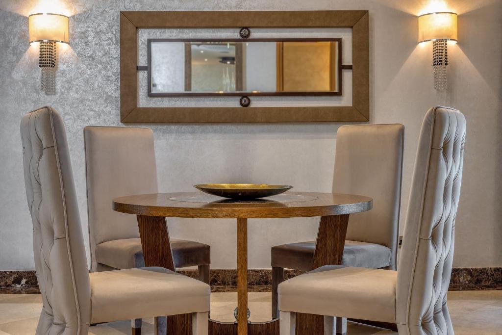 a dining room table with chairs and a mirror at Parklane, a Luxury Collection Resort & Spa, Limassol in Limassol