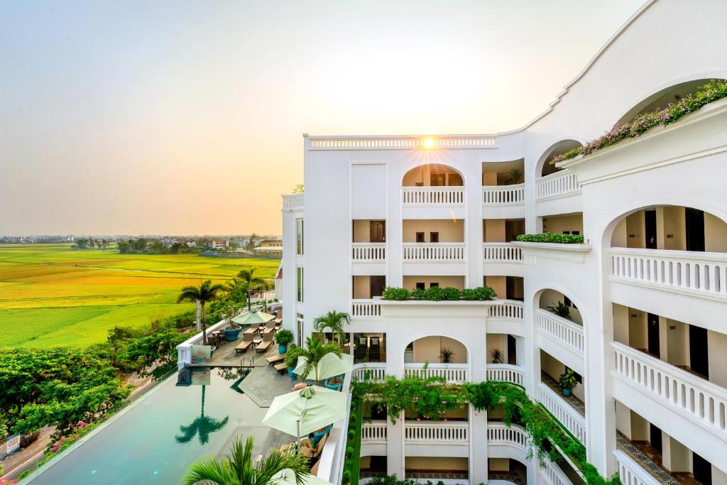 um edifício de apartamentos com piscina e campo de golfe em Lasenta Boutique Hotel Hoian em Hoi An